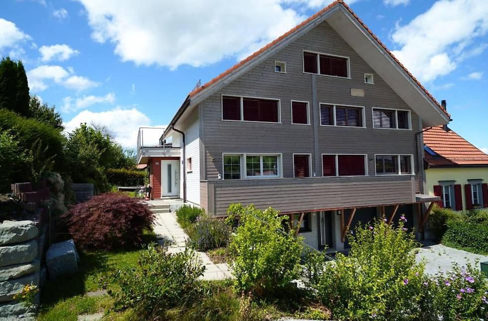 a gray house with red shutters on it at Ganzes Haus am Bodensee in den Bergen im Appenzell in Heiden