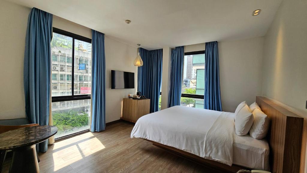 a hotel room with a bed and a large window at UNO Express Asoke Sukhumvit Bangkok in Bangkok