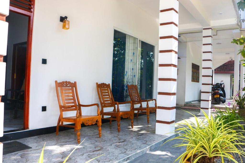 a group of chairs sitting on the porch of a house at Malika homestay in Midigama East