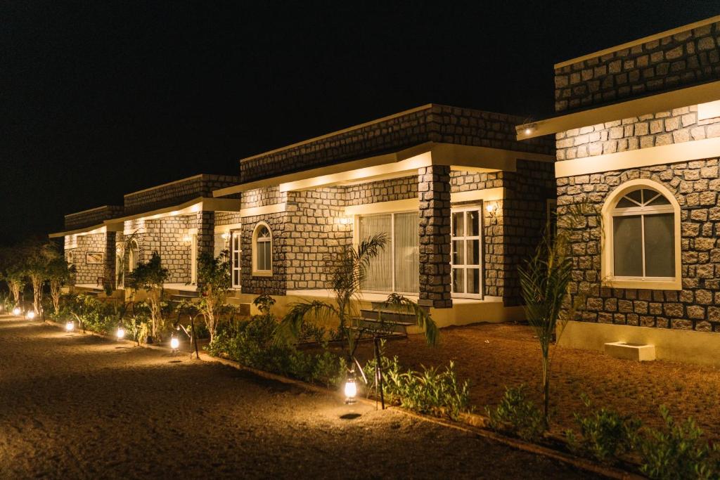 a building with lights in front of it at night at Soma Jawai in Bijāpur