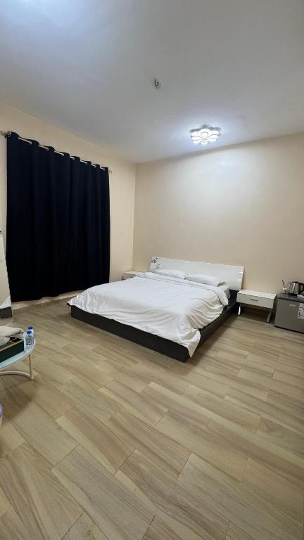 ein Schlafzimmer mit einem Bett und einem Holzboden in der Unterkunft Arlo Oman in Firq
