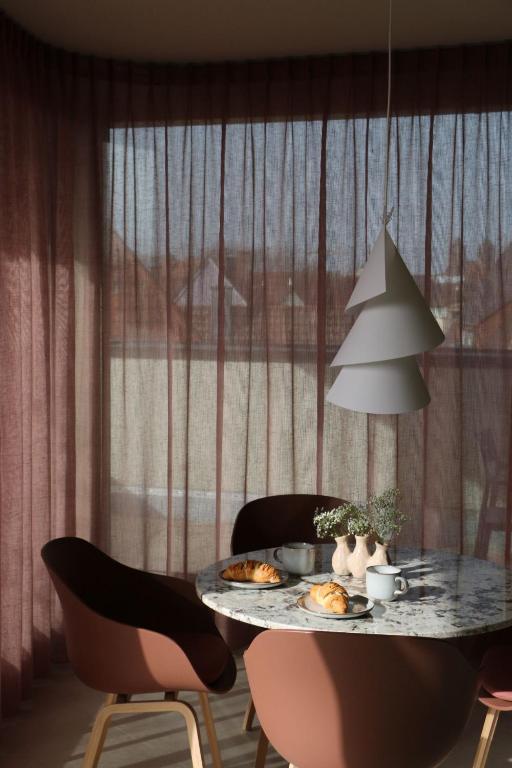 a table with plates of food on it with chairs at Rex Palast in Memmingen