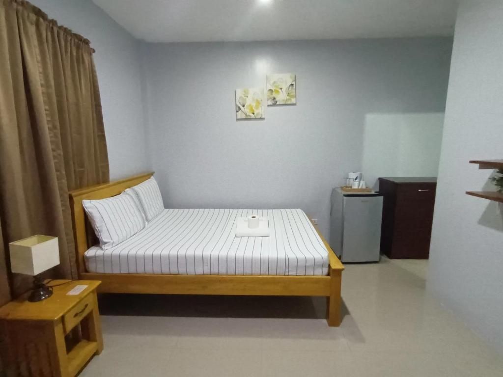 a small bedroom with a bed and a table at Grae’s Apartelle in Moalboal