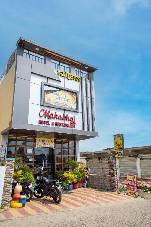 a building with motorcycles parked in front of it at Mahabhoj Hotel & Restaurant in Mandarmoni