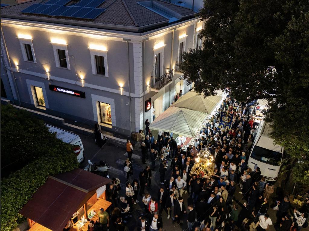 a crowd of people standing in front of a building at La Chambre in Paola