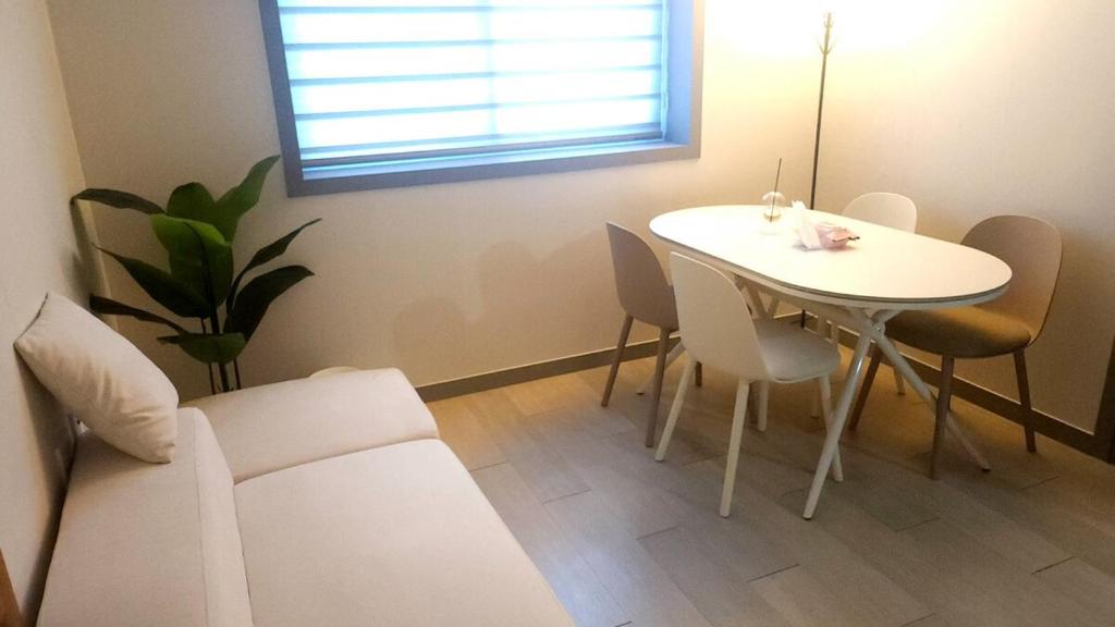 a living room with a white table and chairs at Pine-tree stay Mini in Samgong