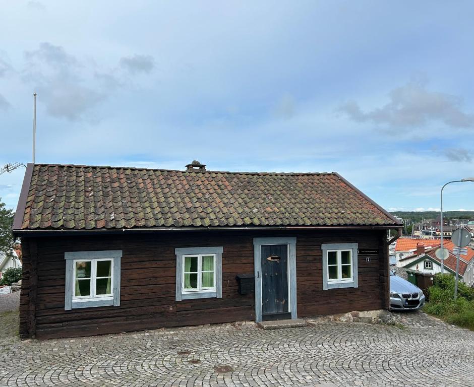 a small wooden house sitting on top of a road at Stuga med havsutsikt in Strömstad