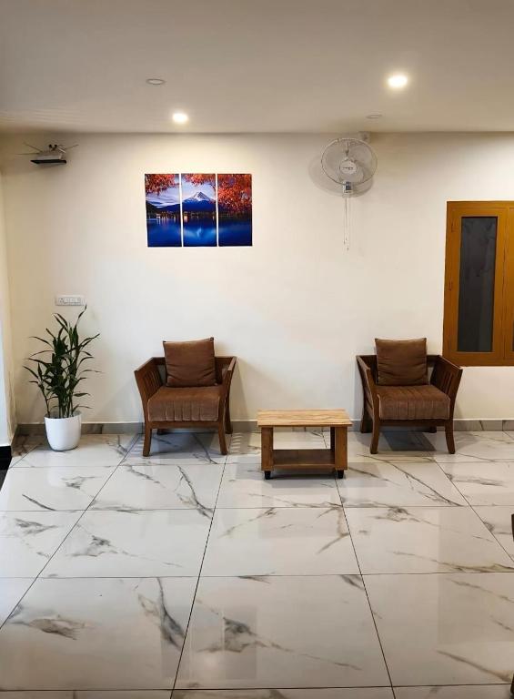 a waiting room with two chairs and a table at Aman Residency in Thodupuzha