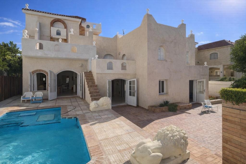 a large house with a swimming pool in front of it at Beach Family Villa - Private Pool - Sea view - Up to 14 guests- only 40 Meters to the Beach! in Alexandria