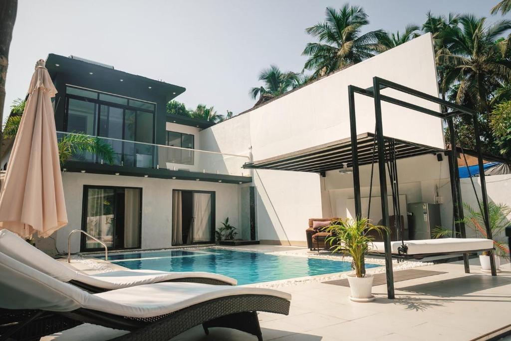 a villa with a swimming pool and a house at White Tiger Villa in Goa