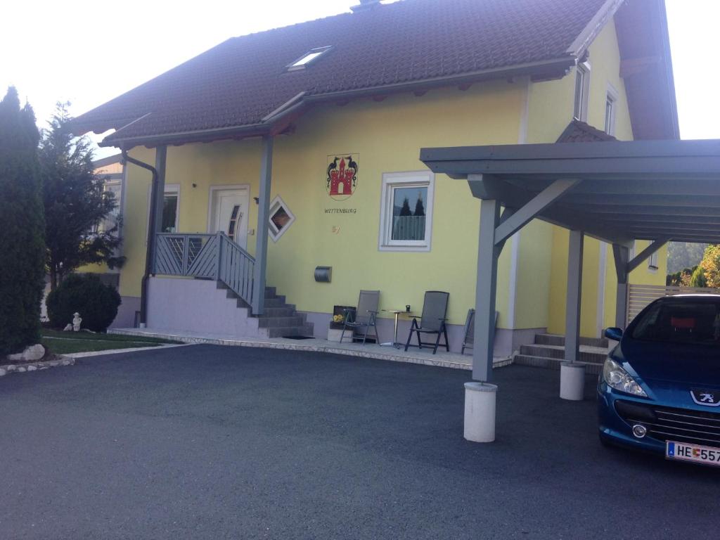 a yellow house with a car parked in front of it at Ferienwohnung Wittenburg in Hermagor