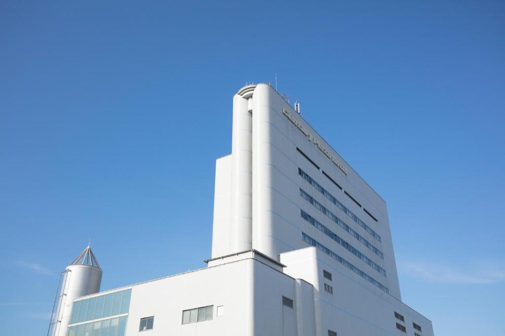 a white building with a blue sky in the background at Century Plaza Hotel in Tokushima