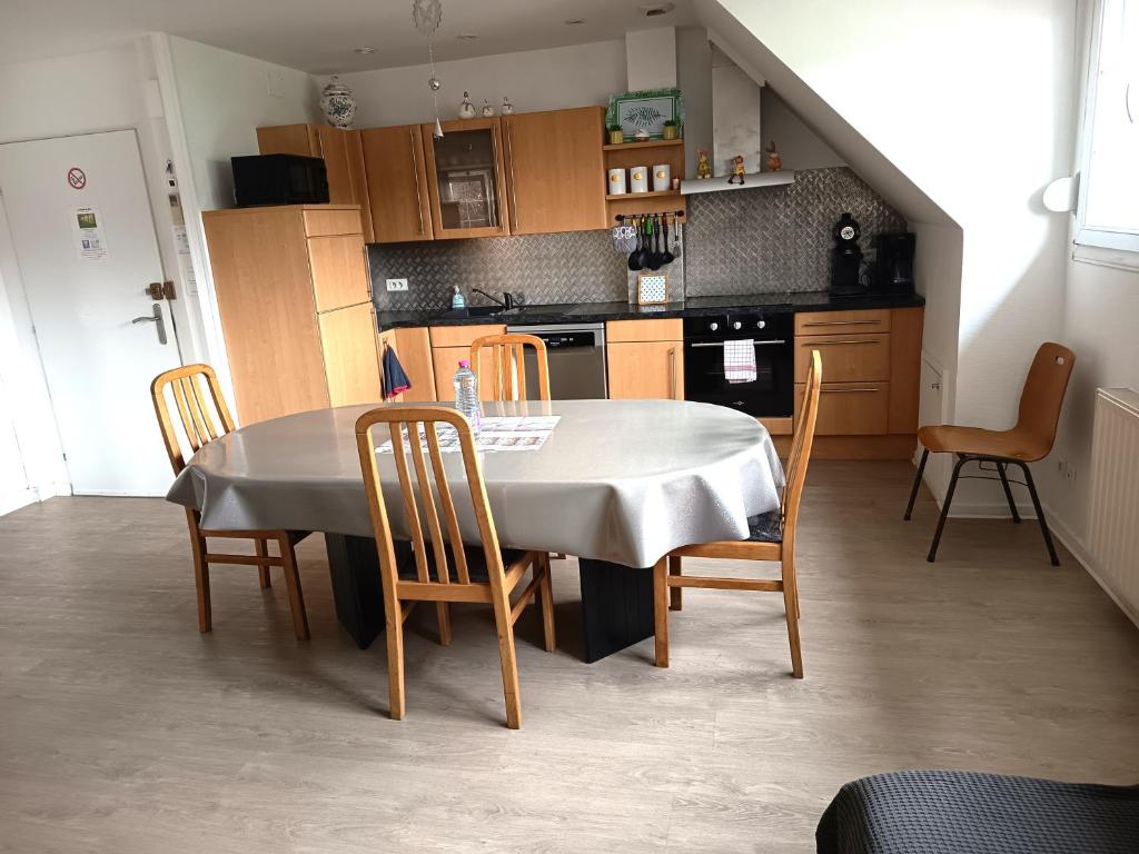 a kitchen with a table and chairs and a table and a kitchen at A l'Orée du Bois ''Les Hêtres'' in Guewenheim