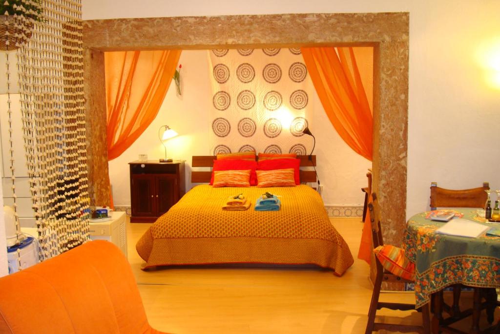 Vovo House في لشبونة: غرفة نوم مع سرير مع وسائد برتقالية