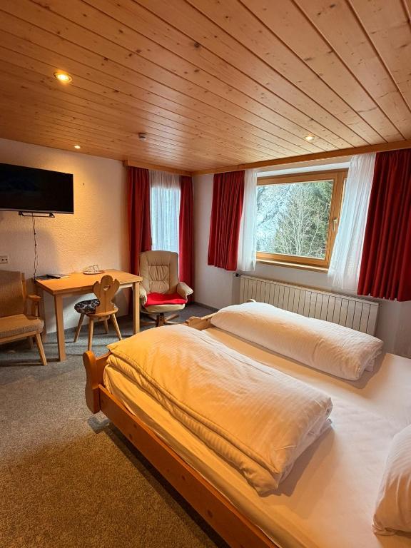 a bedroom with two beds and a table in it at Haus Brunelle in Damuls