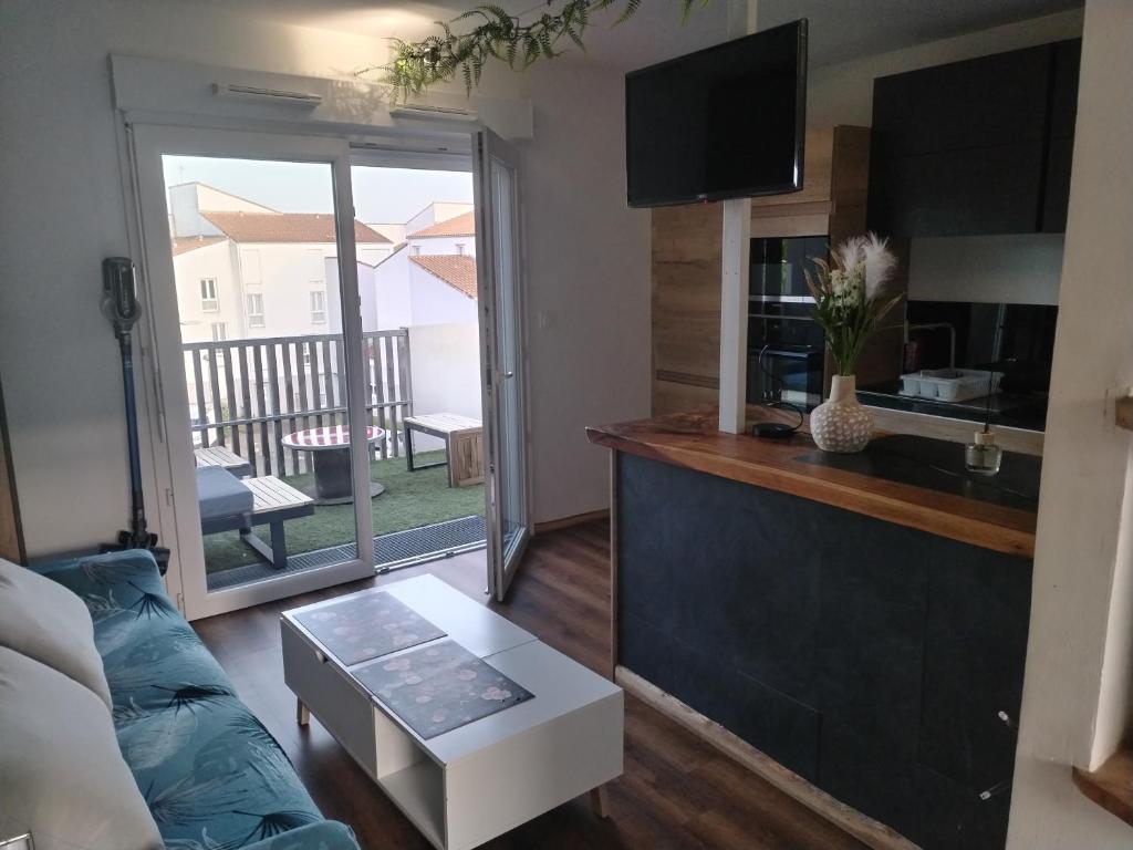 a living room with a couch and a table at Grand studio cosy et lumineux in La Rochelle