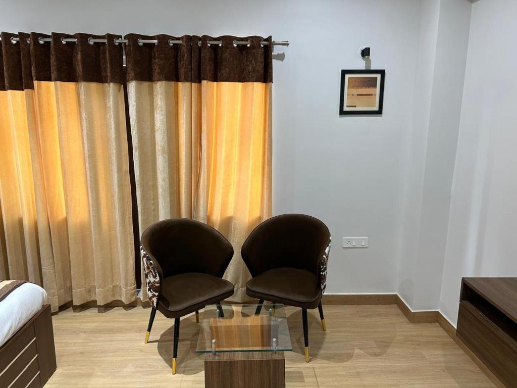two chairs sitting in a room with a window at STARLIT Hotel, Ajmer in Madār