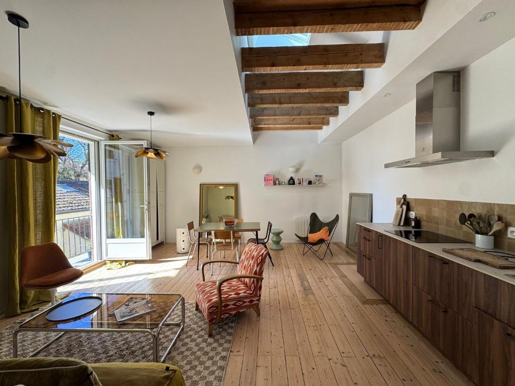 a kitchen and living room with a table and chairs at L’appartement 39 in Lons-le-Saunier