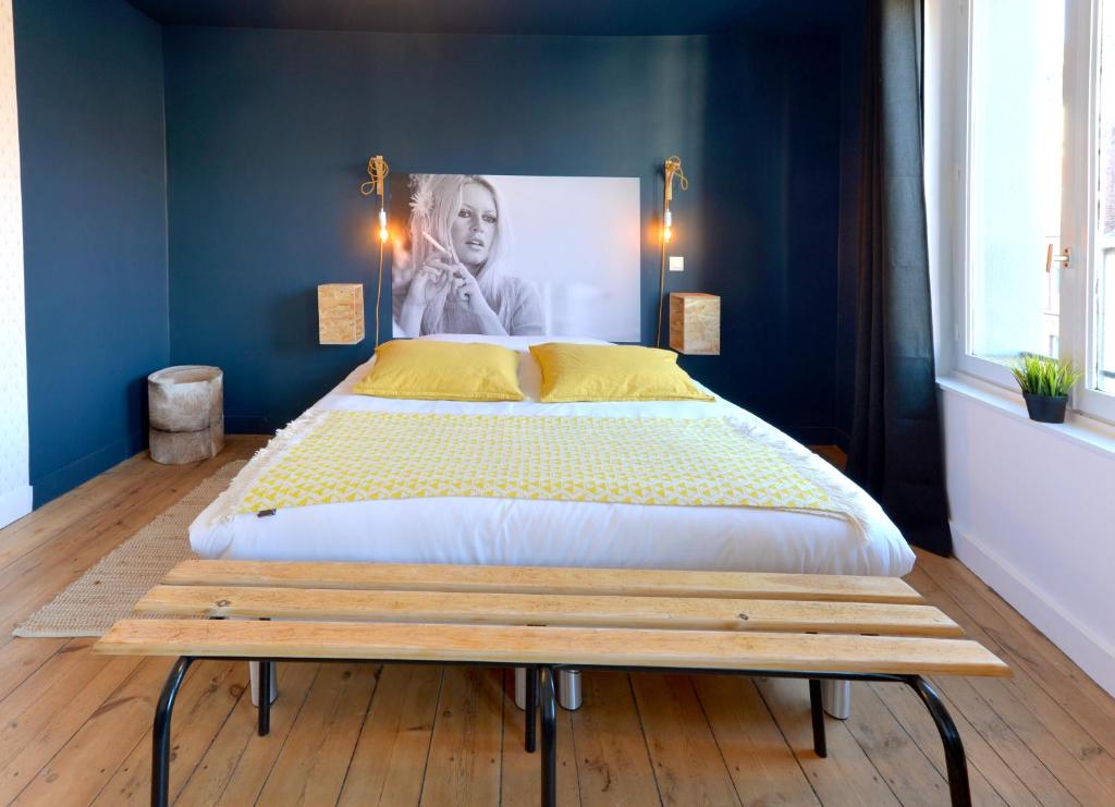 a bed sitting on top of a wooden floor at Princesse Apart'hôtel in Lille