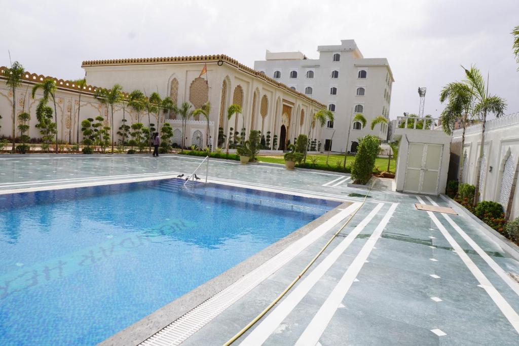 a swimming pool in front of a building at Neendar Heritage Resort in Jaipur