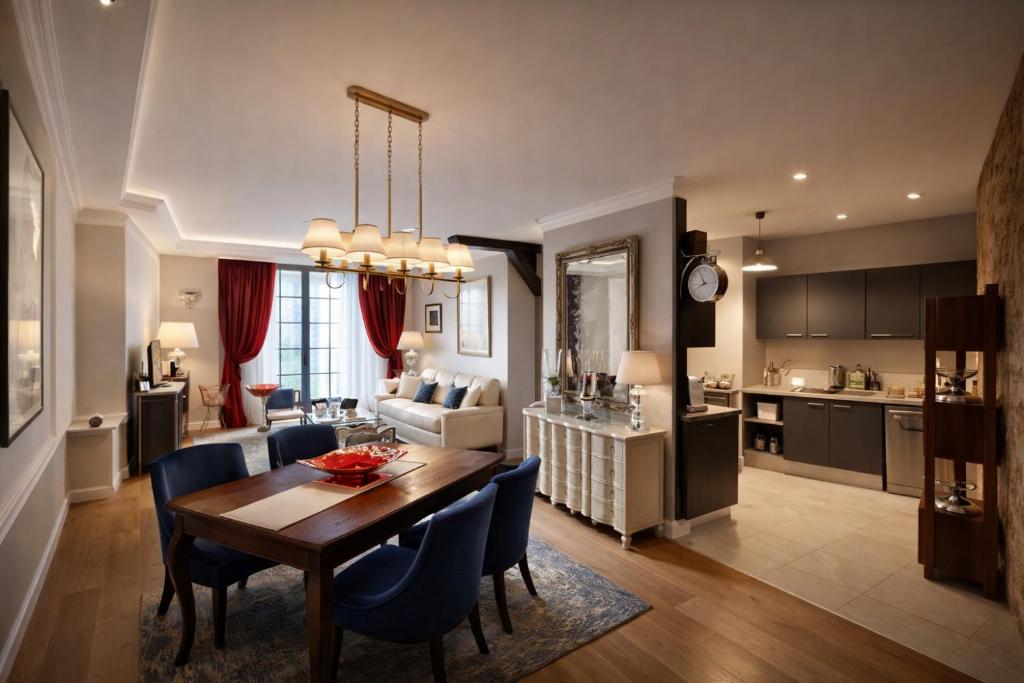 a kitchen and living room with a table and chairs at La Salamandre - Un écrin médiéval pour vos souvenirs - Imaginez-vous, réveillé par le murmure de Sarlat, dans un appartement spacieux et chaleureux, au cœur de la Cité classée - 2 chambres - Une magie à vivre sans modération - Réservez dès maintenant ! in Sarlat-la-Canéda