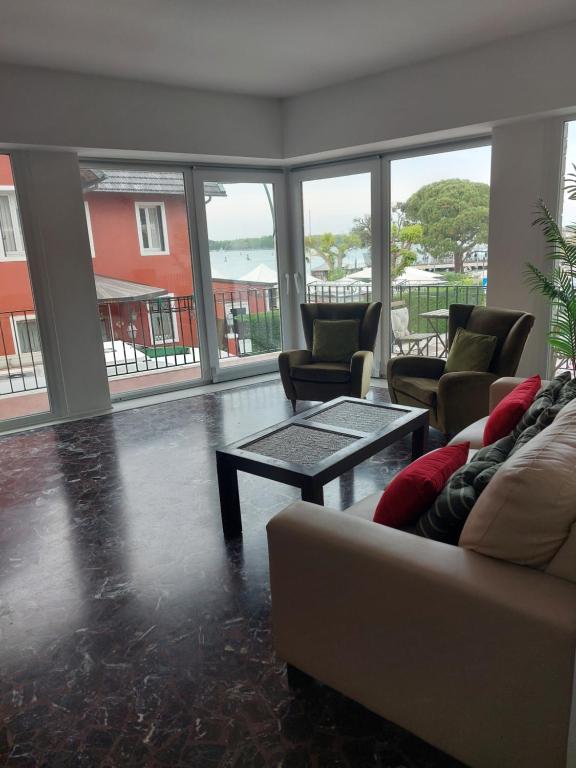 a living room with a couch and a table and windows at Splendid Lido in Venice-Lido