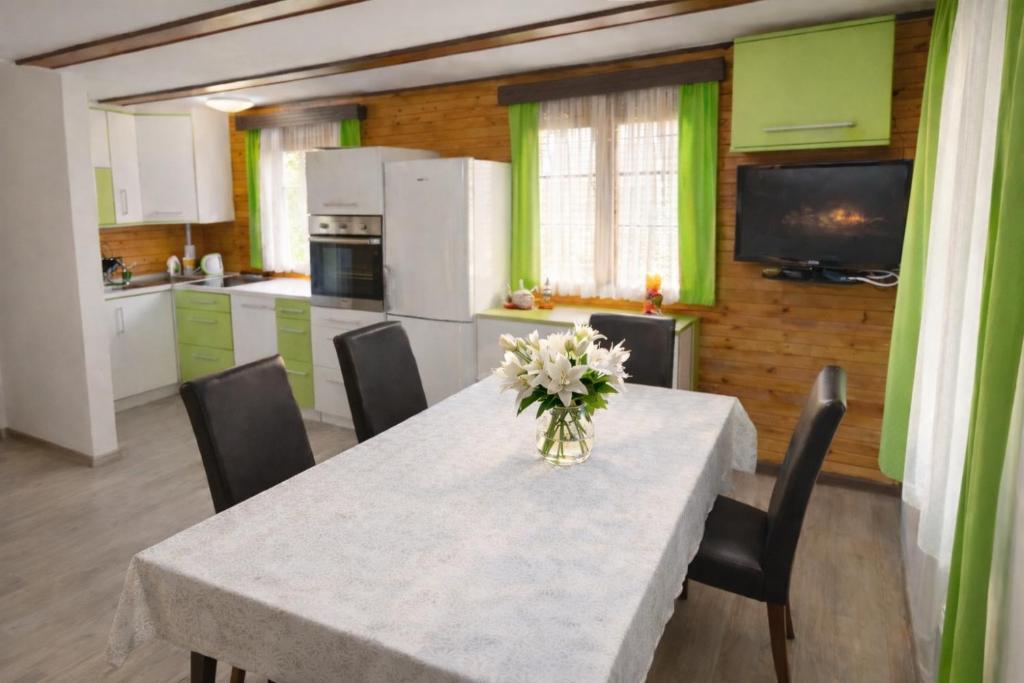 a kitchen with a table with a vase of flowers on it at Hiška Arijela, Terme Čatež, oaza sprostitve, Slovenija in Brežice