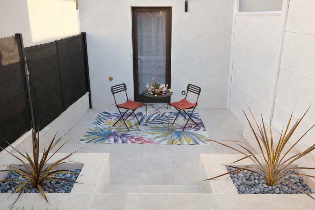 two chairs and a table on a patio at Studio du port avec jardin privé in Saint-André-de-Cubzac