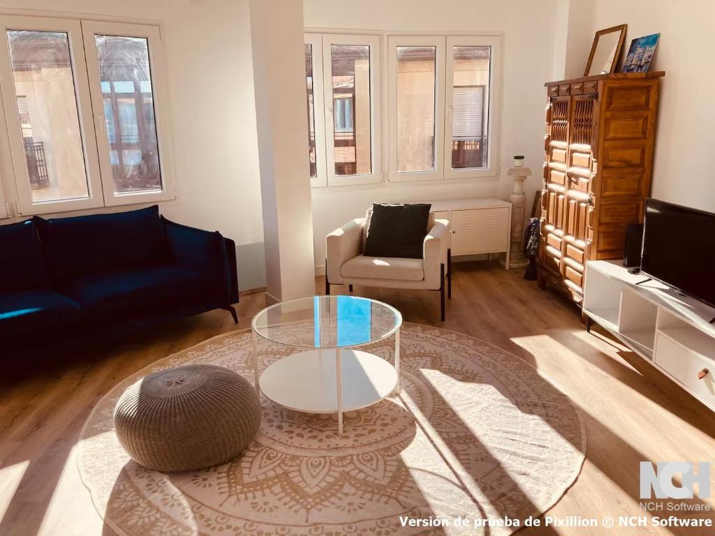 a living room with a glass table and a couch at Fuentes 8 in Soria