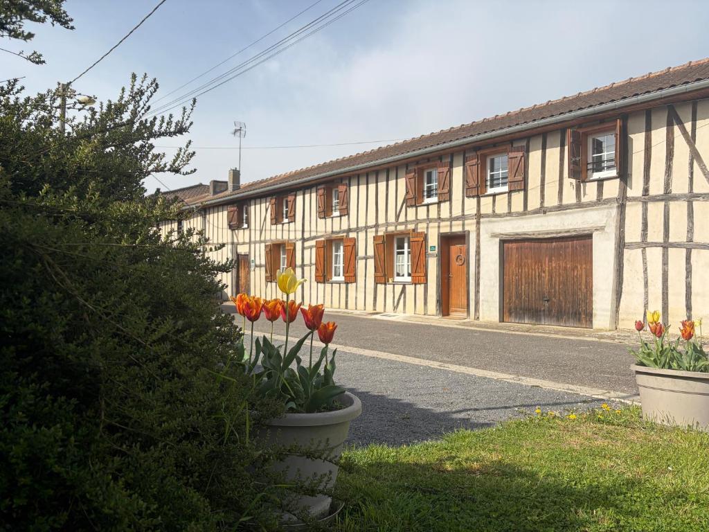a building with orange tulips in front of it at Le Bois Flotté in Arrigny