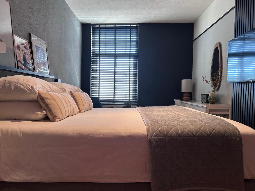 ein Schlafzimmer mit einem großen Bett und einer blauen Wand in der Unterkunft Hotel chic room in Heerlen