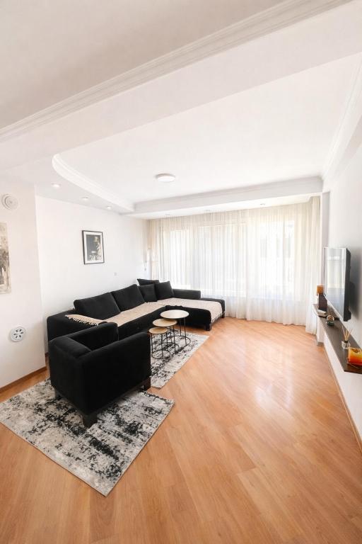 a living room with a black couch and a table at Villa Fantasy Premium Lakeview in Ohrid