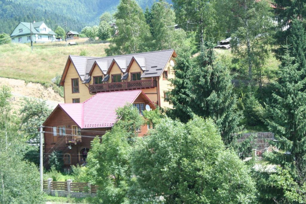 a large wooden house with a red roof at Skarbivka in Vorokhta