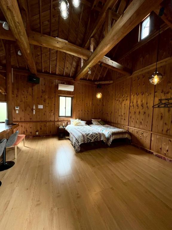 a bedroom with a bed in a room with wooden walls at Retreat 舞月 in Tanabe
