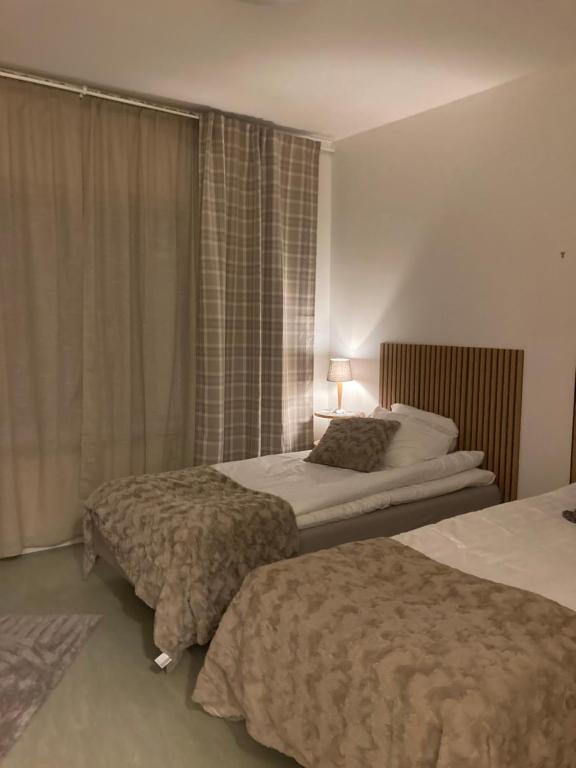 a hotel room with two beds and a window at Systemairhallen Bed&Breakfast in Skinnskatteberg