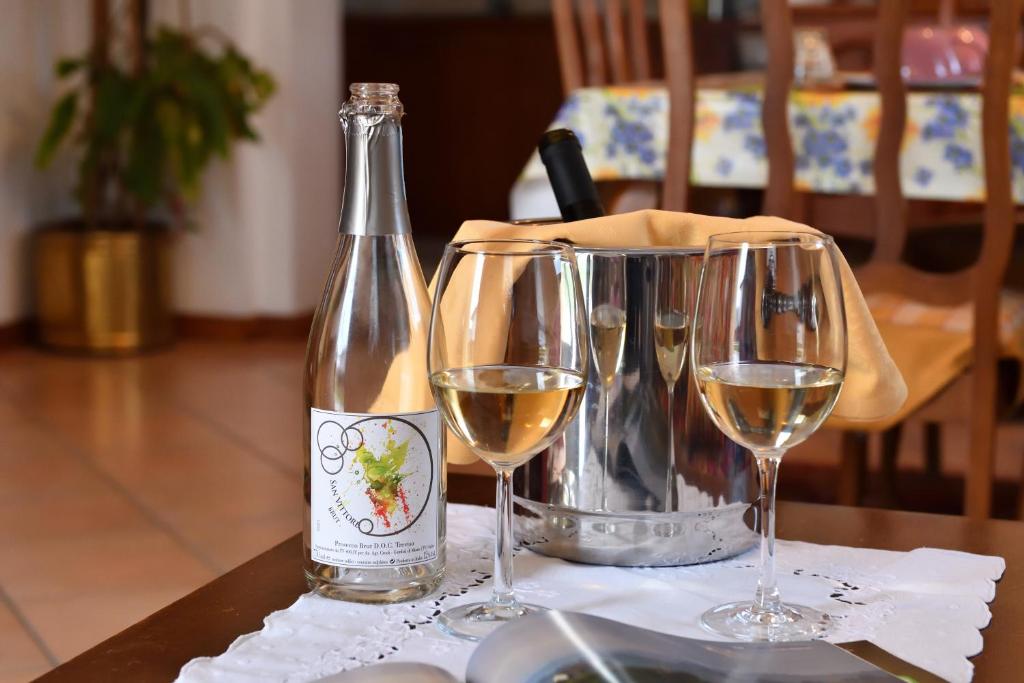butelkę wina i dwa kieliszki wina na stole w obiekcie Agriturismo Memento w mieście Follina