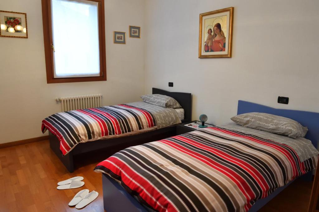 sypialnia z dwoma łóżkami i oknem w obiekcie Agriturismo Memento w mieście Follina