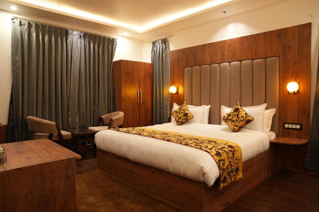 a hotel room with a large bed and a desk at Green Inn in Pahalgām
