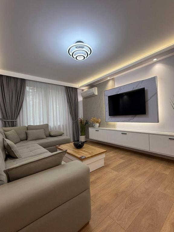 a living room with a couch and a flat screen tv at Abla's sweet home in Tirana