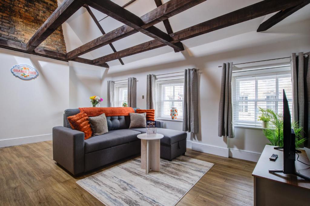 a living room with a couch and a table at Modern 1 Bed - Beams - Parking in Stamford