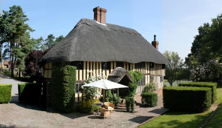 un grand bâtiment avec un toit en gazon et un parasol dans l'établissement Knelle Dower Studio, à Northiam