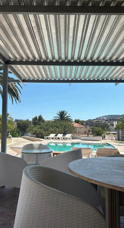 a patio with a table and chairs and a pool at Garden Villa in Karpathos
