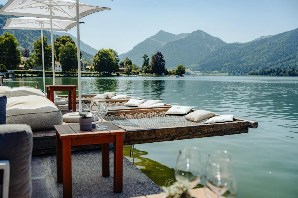 a dock with a table and chairs on a lake at Seehotel Schlierseer Hof in Schliersee