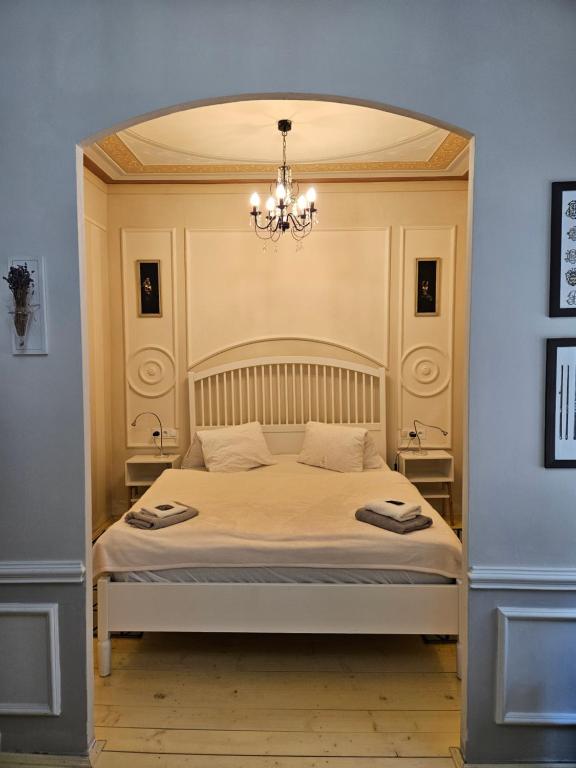 a bedroom with a large bed with a chandelier at Apartmán Marína in Banská Štiavnica