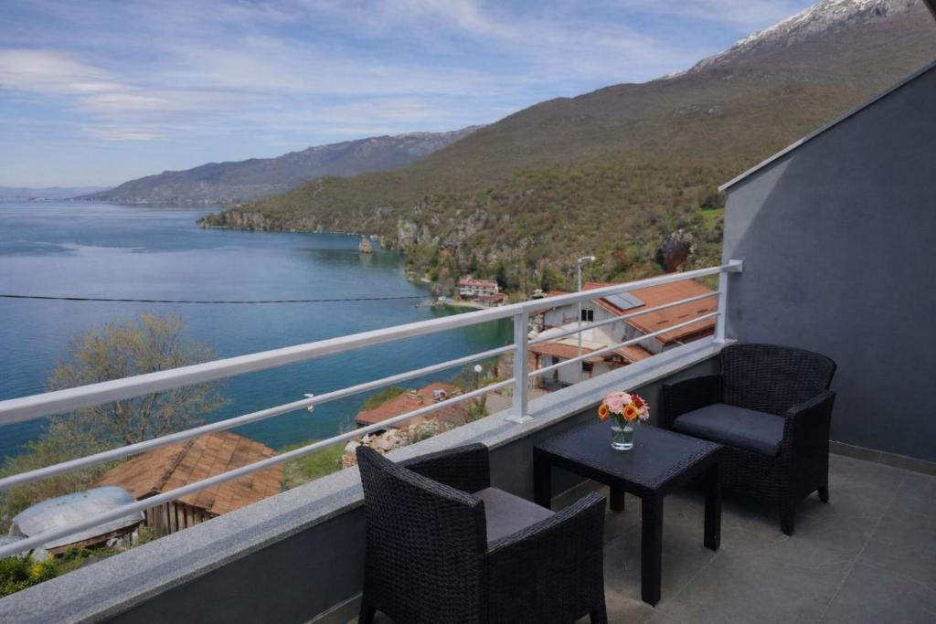 a balcony with a table and chairs and a view of a lake at Apartments Marko in Ohrid