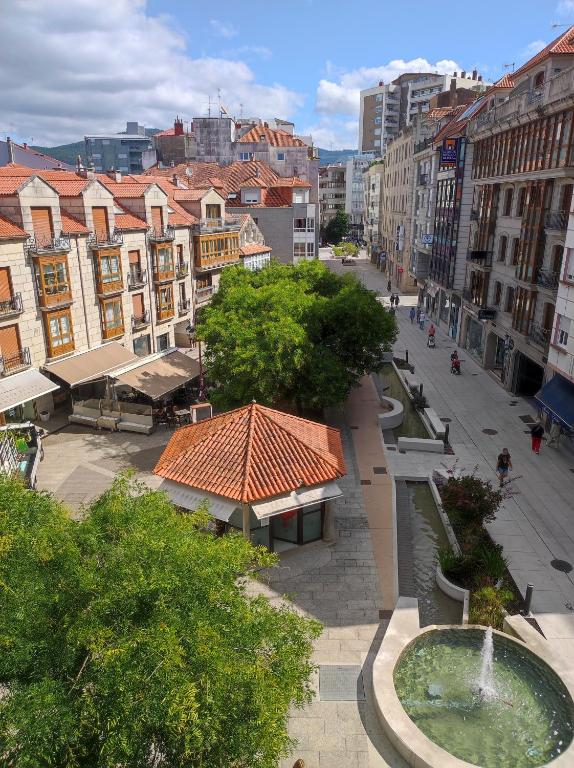 a city with a fountain in the middle of a street at Centro1 in Vilagarcia de Arousa