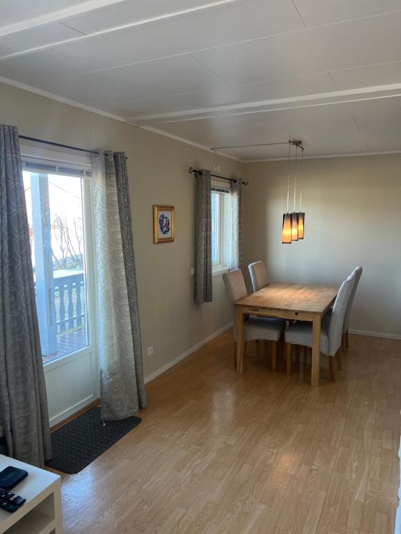 a dining room with a wooden table and a window at Leilighet i Vadsø in Vadsø