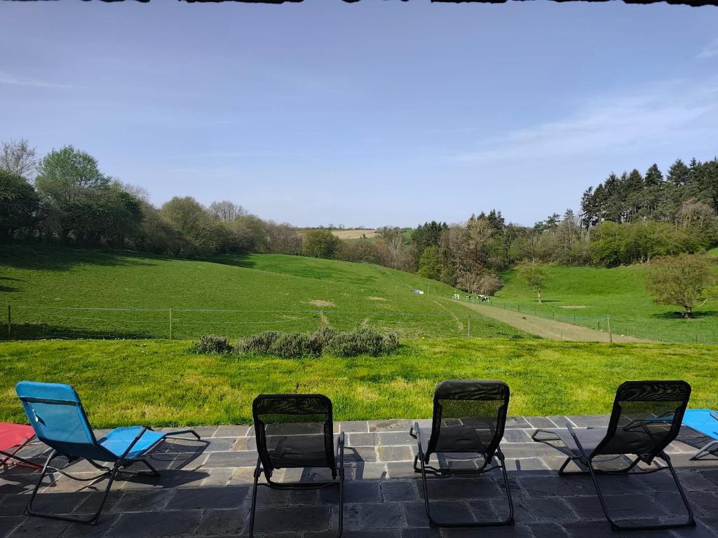 a group of chairs sitting on a patio with a field at La randonnée in Beaumont