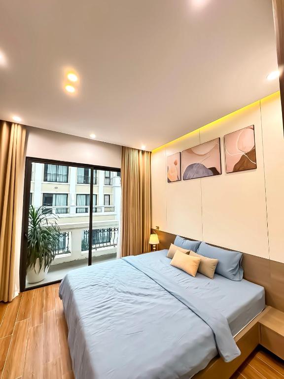 a bedroom with a large bed and a large window at AnChi Homestay in Hòa Bình