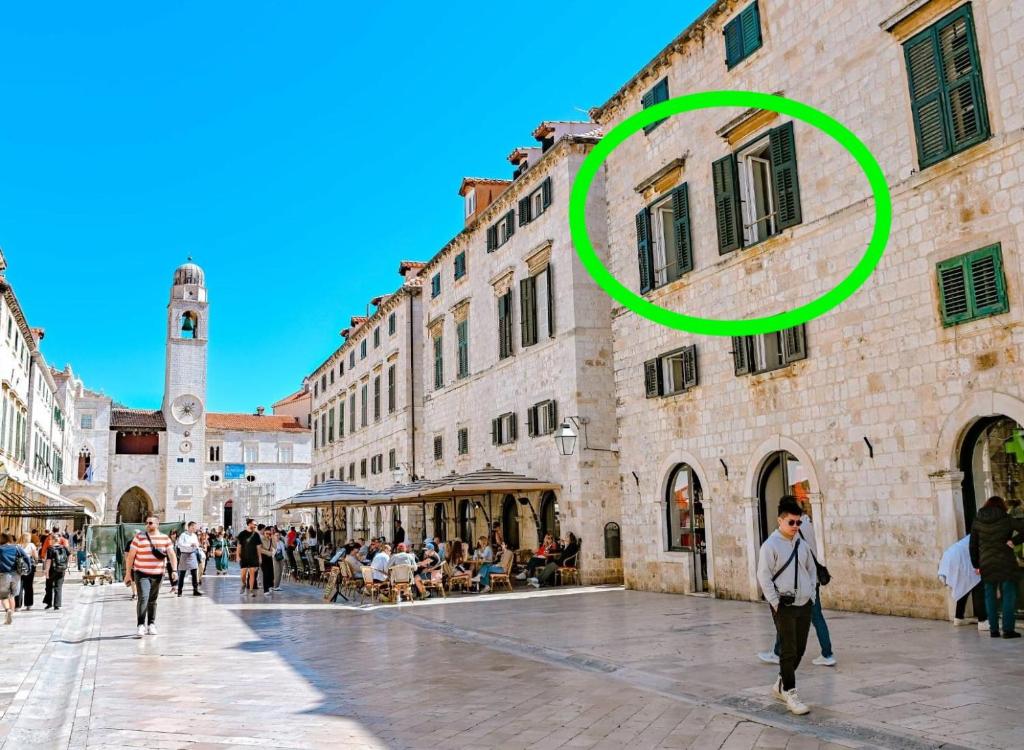 a person walking in a street in a city at Stradun Main Street Residence in Dubrovnik